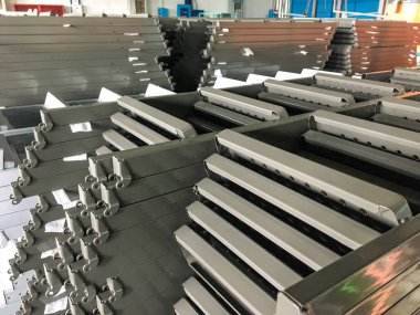 Toz kaplama hattı. Metal paneller, üstteki taşıma hattında askıya alındı. Elektrostatik alanda boyama ürünleri.