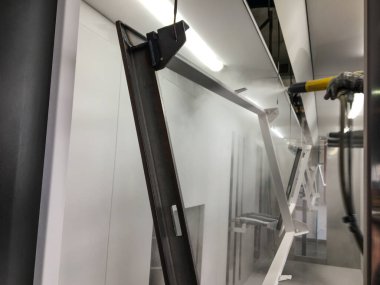 Toz kaplama hattı. Metal paneller, üstteki taşıma hattında askıya alındı. Elektrostatik alanda boyama ürünleri.
