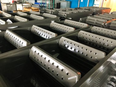 Toz kaplama hattı. Metal paneller, üstteki taşıma hattında askıya alındı. Elektrostatik alanda boyama ürünleri.