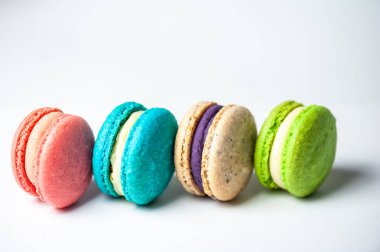 Mavi arka planda farklı renklerde badem kurabiyelerinin yakın çekimi. Mutfak ve yemek pişirme konsepti. Lezzetli renkli badem kurabiyeleri..