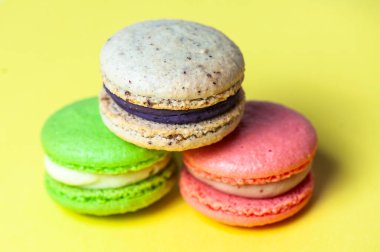 Mavi arka planda farklı renklerde badem kurabiyelerinin yakın çekimi. Mutfak ve yemek pişirme konsepti. Lezzetli renkli badem kurabiyeleri..