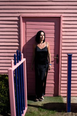 Parkta poz veren siyah elbiseli güzel bir kadın.