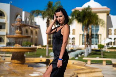 Siyah elbiseli, mavi gömlekli güzel bir kadın.