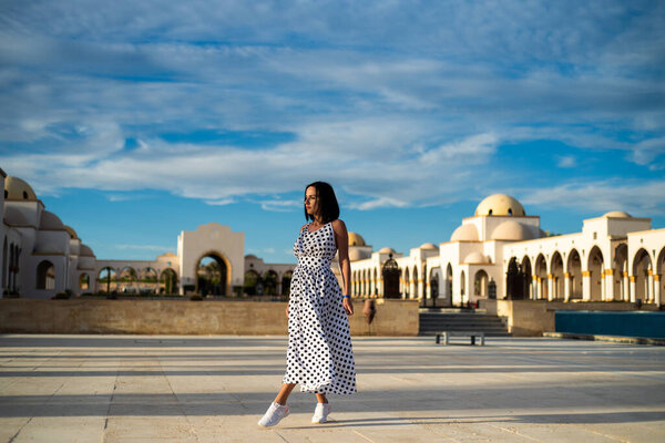 beautiful young woman in a dress on the background of the old city