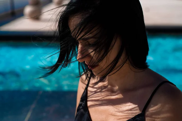 ビーチでポーズをとっている黒い水着の美しい若い女性 — ストック写真