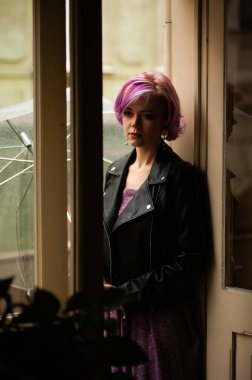 Yağmurlu bir gün. Parlak şemsiyeli gülümseyen kadın