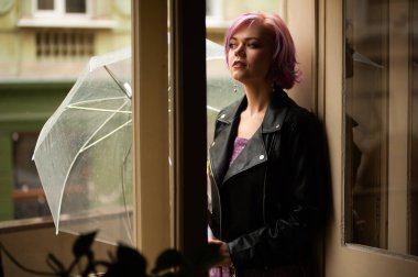 Yağmurlu bir gün. Parlak şemsiyeli gülümseyen kadın