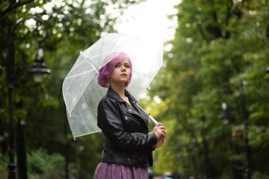 Yağmurlu bir gün. Parlak şemsiyeli gülümseyen kadın