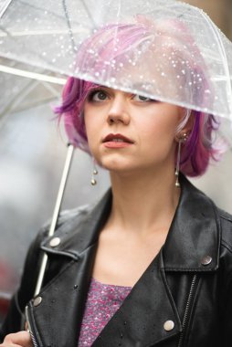 Yağmurlu bir gün. Parlak şemsiyeli gülümseyen kadın