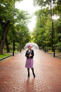 Yağmurlu bir gün. Parlak şemsiyeli gülümseyen kadın