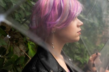 Yağmurlu bir gün. Parlak şemsiyeli gülümseyen kadın