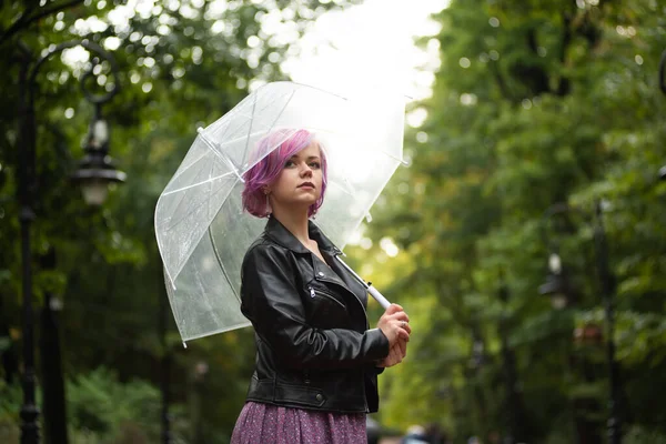 Yağmurlu bir gün. Parlak şemsiyeli gülümseyen kadın