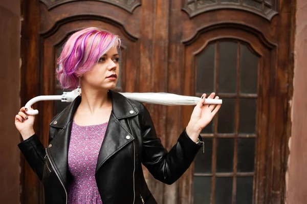 Yağmurlu bir gün. Parlak şemsiyeli gülümseyen kadın