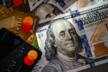 Lviv, Ukrayna - 05.20.2022: Arkaplanda banka kartı ve para faturaları kavramı