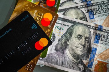 Lviv, Ukrayna - 05.20.2022: Arkaplanda banka kartı ve para faturaları kavramı