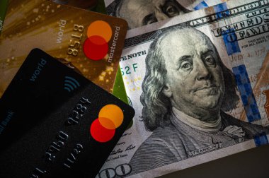 Lviv, Ukrayna - 05.20.2022: Arkaplanda banka kartı ve para faturaları kavramı