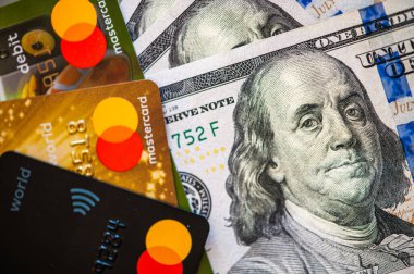 Lviv, Ukrayna - 05.20.2022: Arkaplanda banka kartı ve para faturaları kavramı