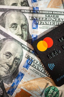 Lviv, Ukrayna - 05.20.2022: Arkaplanda banka kartı ve para faturaları kavramı