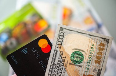 Lviv, Ukrayna - 05.20.2022: Arkaplanda banka kartı ve para faturaları kavramı