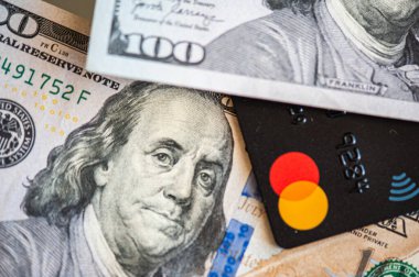 Lviv, Ukrayna - 05.20.2022: Arkaplanda banka kartı ve para faturaları kavramı