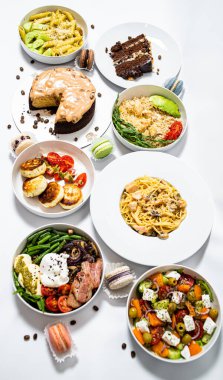 Beyaz arka plandaki et, sebze ve tatlılardan oluşan şenlikli yemekler. Menü ayarlandı.