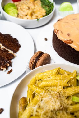 Beyaz arka plandaki et, sebze ve tatlılardan oluşan şenlikli yemekler. Menü ayarlandı.