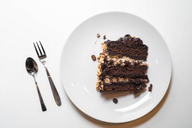 Beyaz arka planda çikolatalı tatlı. Fındıklı ve kuru üzümlü lezzetli pasta. Üst görünüm, düz görünüm, kopyala