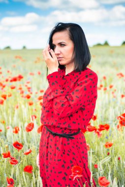 Elinde çiçek olan romantik kadın haşhaş tarlasında