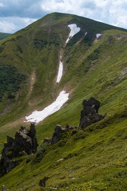 Yeşil çimenleri ve mavi gökyüzü olan güzel dağ manzarası