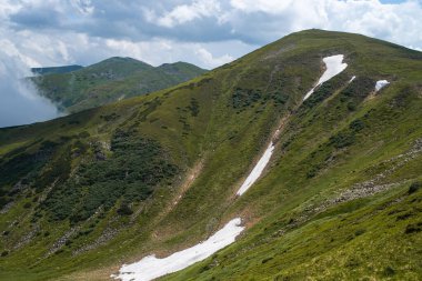 Dağları ve mavi gökyüzü olan güzel bir manzara.
