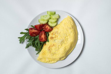 Kızarmış patates, sebzeli ve peynirli beyaz tabakta.