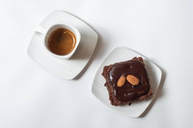 Kahveli çikolatalı kek ve beyaz arka planda çay.