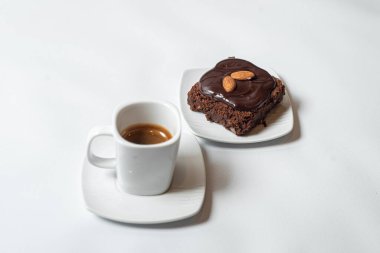 Kahveli çikolatalı kek ve beyaz arka planda çay.