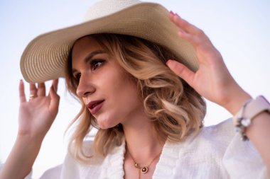 beautiful girl in a white dress and hat in a lavender field at sunset