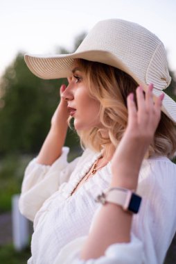 beautiful girl in a white dress and hat in a lavender field at sunset