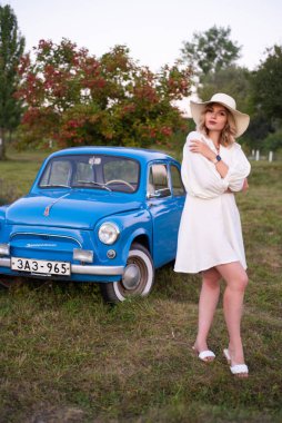 beautiful girl in a white dress and hat in a lavender field at sunset