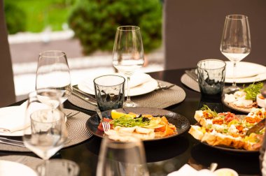 table setting with wine and glasses of red and white plates on the background of the restaurant