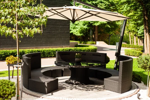 outdoor patio with wooden chairs and green grass