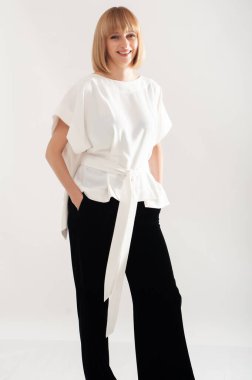 Beyaz takım elbiseli, kendine güvenen iş kadını.