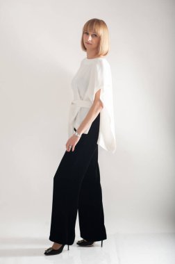 Beyaz takım elbiseli, kendine güvenen iş kadını.