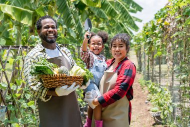Çiftçi aile çiftlikte dikilirken kameraya gülümsüyor..