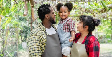 Çiftçi aile çiftlikte dikilirken kameraya gülümsüyor..