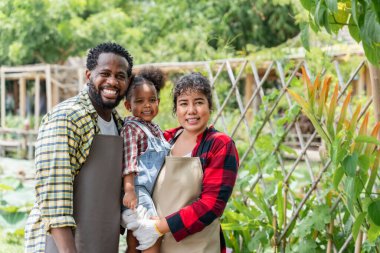 Çiftçi aile çiftlikte dikilirken kameraya gülümsüyor..