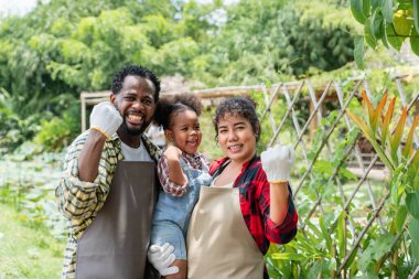 Çiftçi aile çiftlikte dikilirken kameraya gülümsüyor..