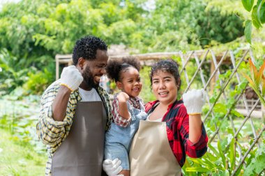 Çiftçi aile çiftlikte dikilirken kameraya gülümsüyor..