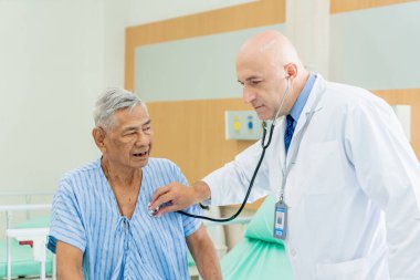 Doktor yaşlı adamı muayene eder ve hastanede iyileşme, sağlık ve sağlık hizmetleri konsepti hakkında konuşur..