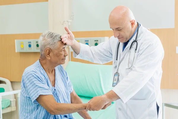 Doktor yaşlı adamı muayene eder ve hastanede iyileşme, sağlık ve sağlık hizmetleri konsepti hakkında konuşur..