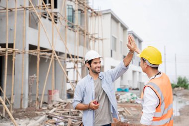 Mühendis ve ustabaşı çeşitli işlevleri kontrol etmek için inşaat alanındaki projeleri tartıştılar ve işaret ettiler..