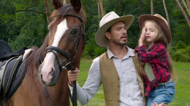 Cowboy och hans dotter smekte en häst — Stockvideo