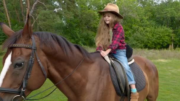 Jung cowgirl im hut reiten sie pferd — Stockvideo